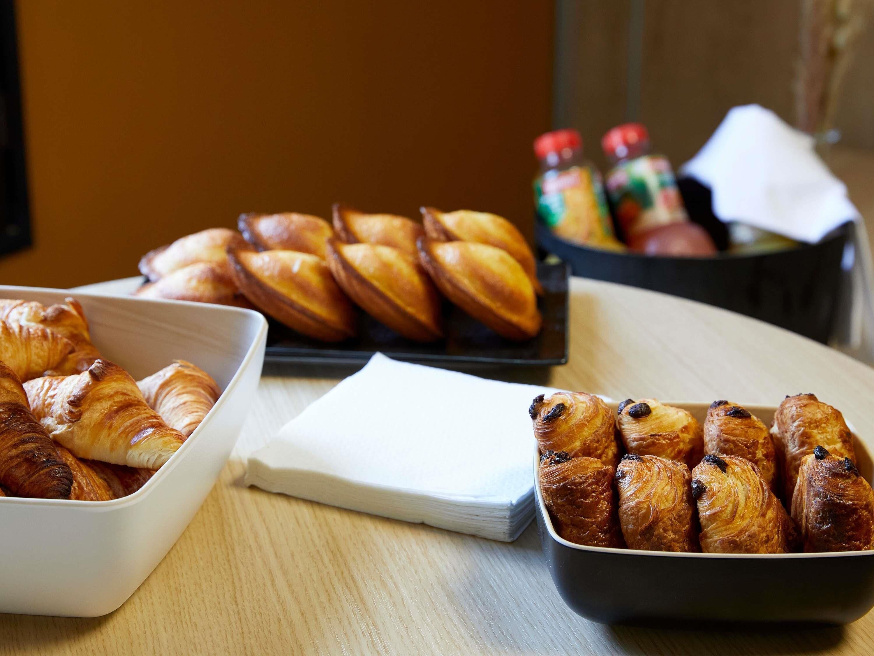 A table with various baked goods, including croissants and pastries, and a napkin.