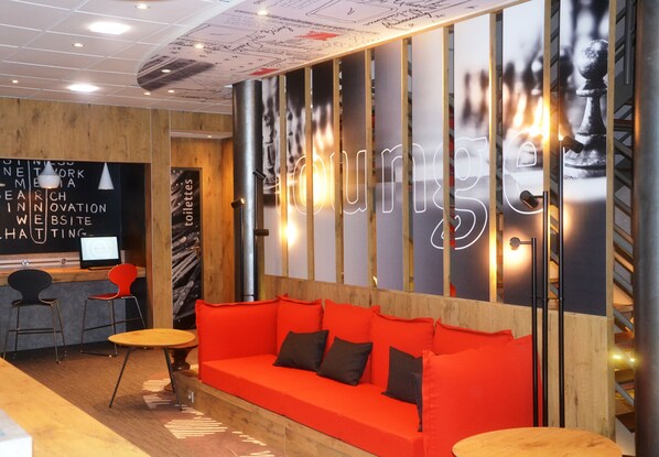 Een moderne zithoek met een rode bank, houten details en een neonreclame.