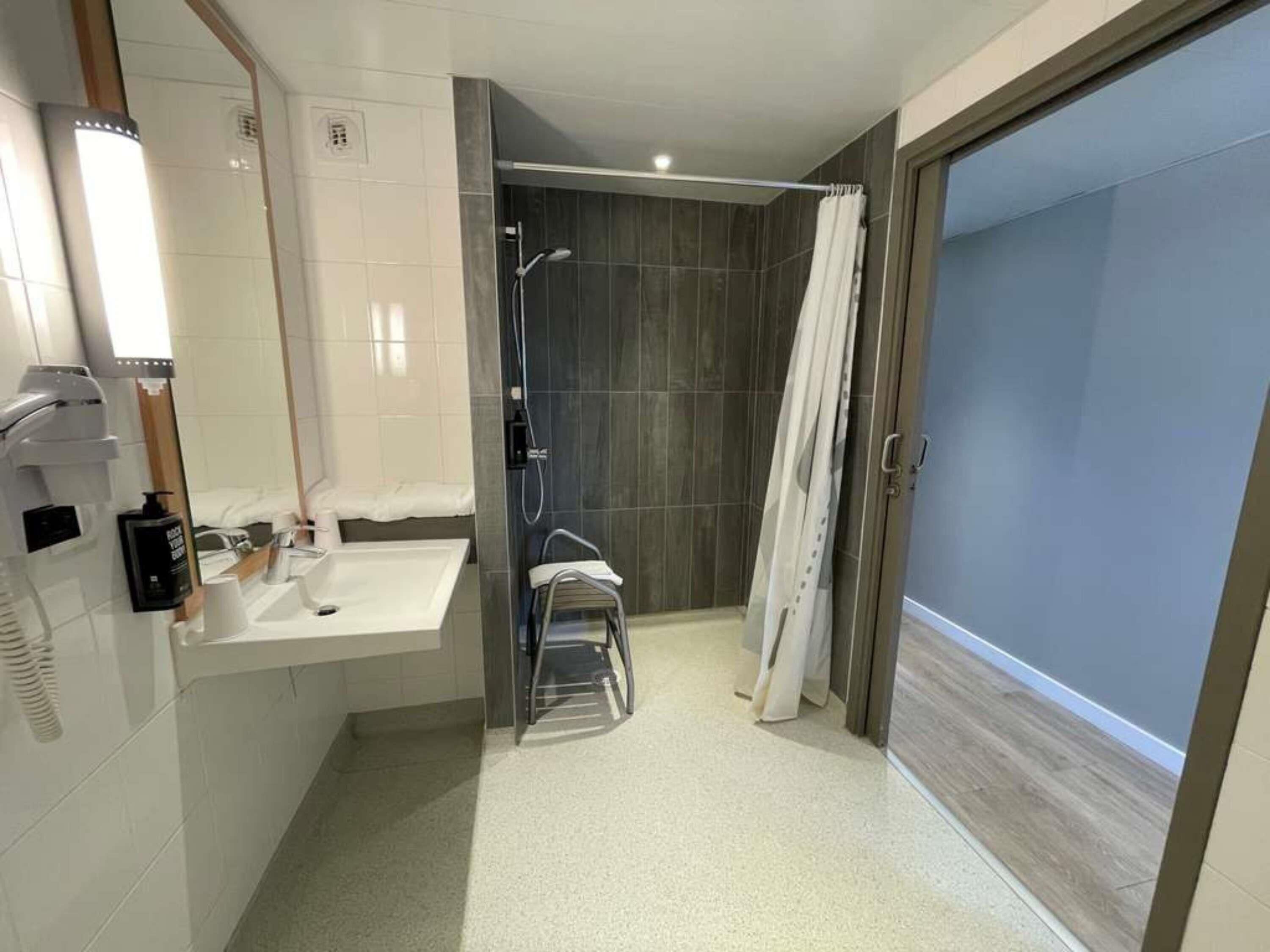 A modern bathroom with a bathtub, shower, and toilet.