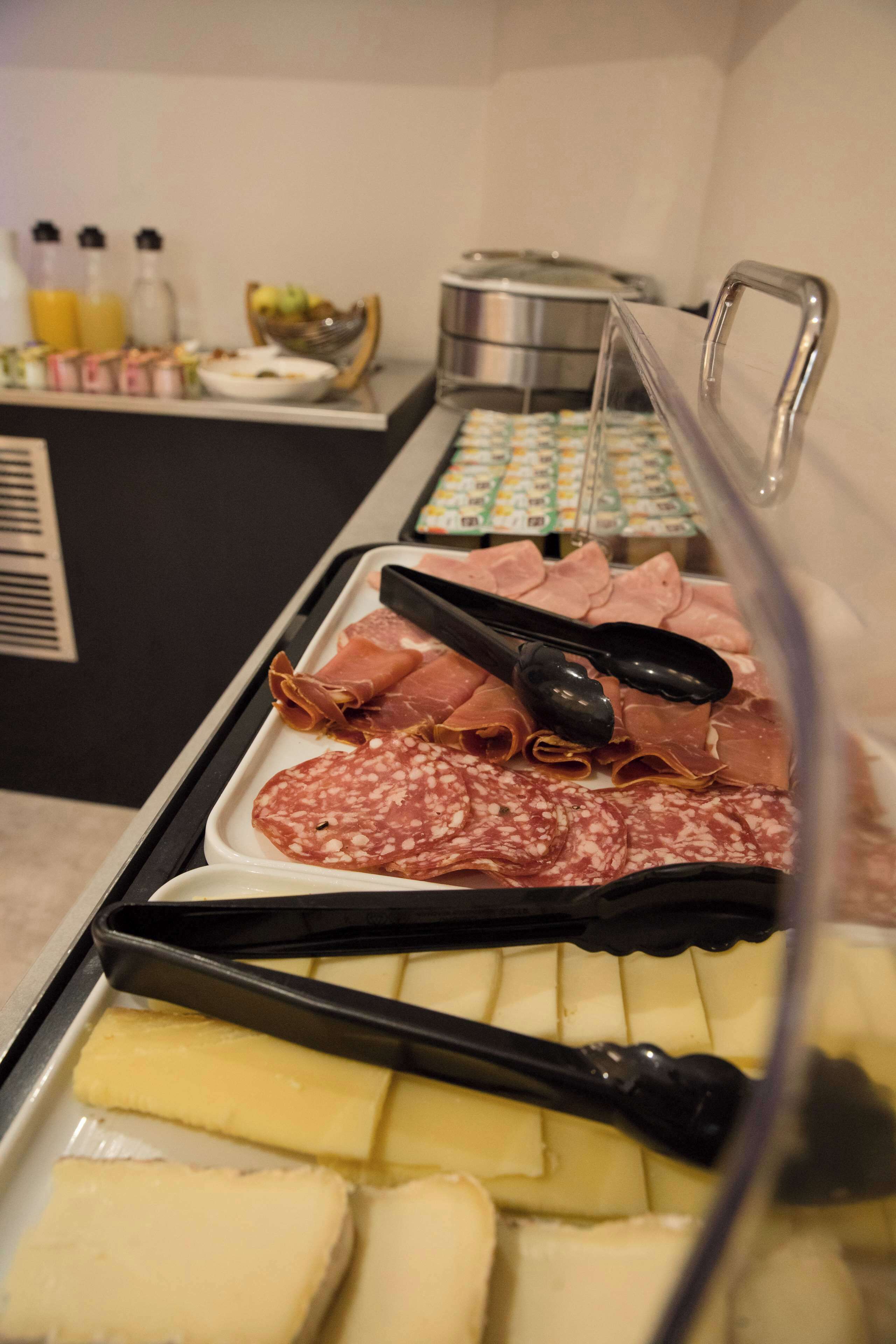 Un bufé con diferentes carnes y quesos.