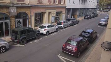 Vista de la calle con coches aparcados, una barbería y un edificio con el letrero 'B35'.
