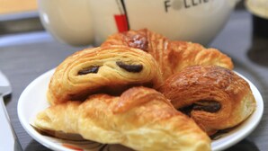 A teapot with a lid and a plate of croissants. - Brit Hotel Calais (Calais)