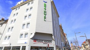 A multi-story building with a sign for 'Hans Anders Opticians' on the ground floor. - Brit Hotel Calais (Calais)