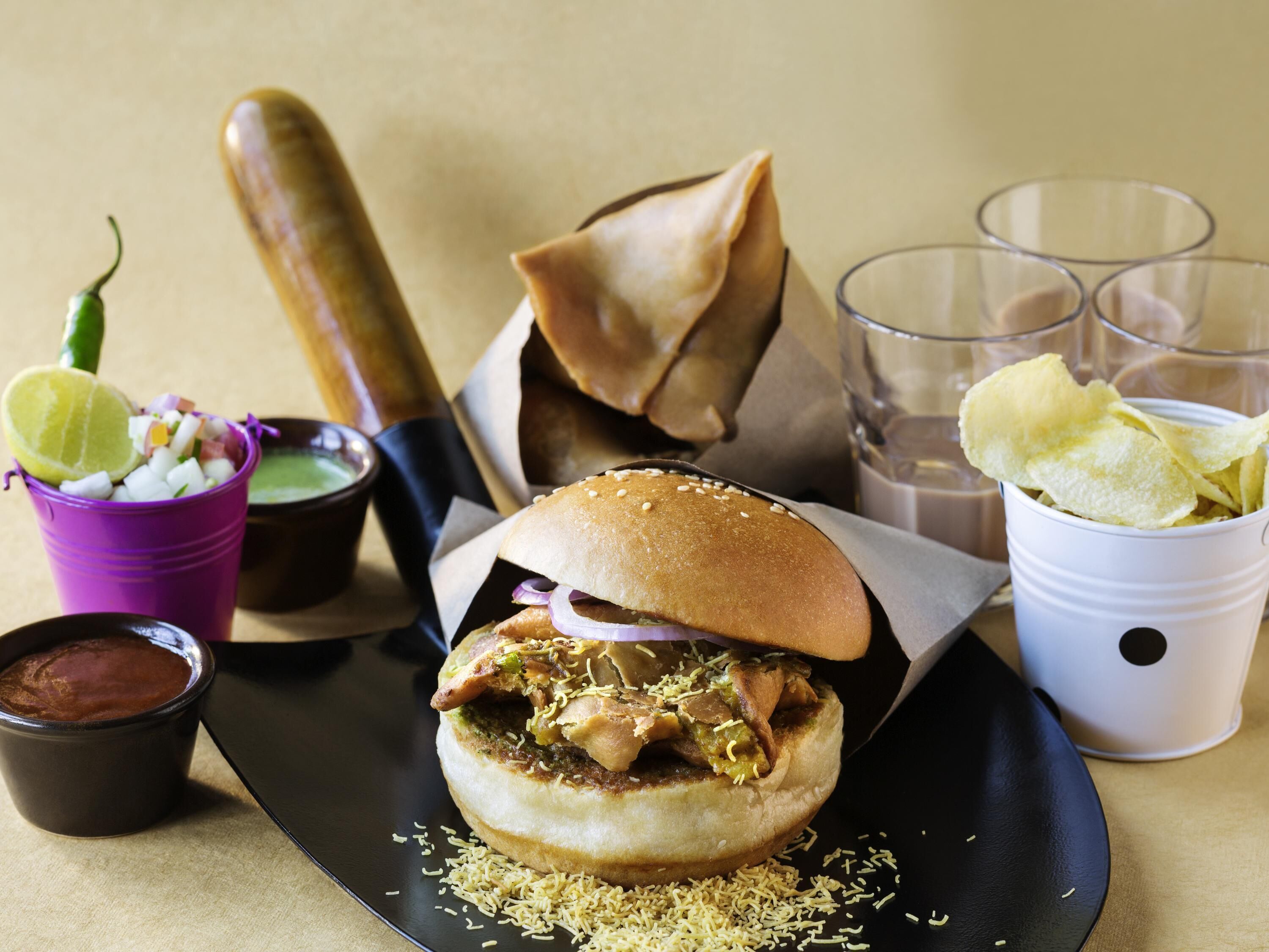 A meal with a sandwich, chips, and drinks on a table.