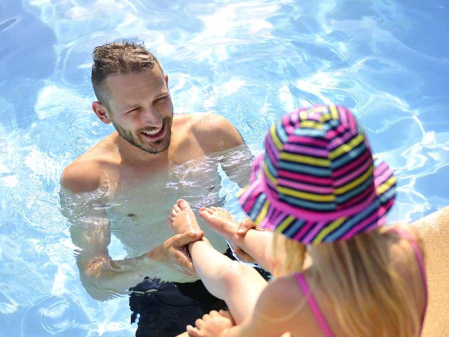 Una piscina al aire libre de temporada, sombrillas, tumbonas