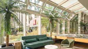 A modern indoor space with a green sofa, two chairs, a coffee table, and a model city display. - ibis Paris 17 Clichy-Batignolles (Paris)