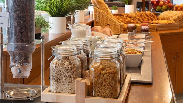 A buffet with various food items, including jars of granola and a coffee dispenser. - ibis Paris 17 Clichy-Batignolles (Paris)