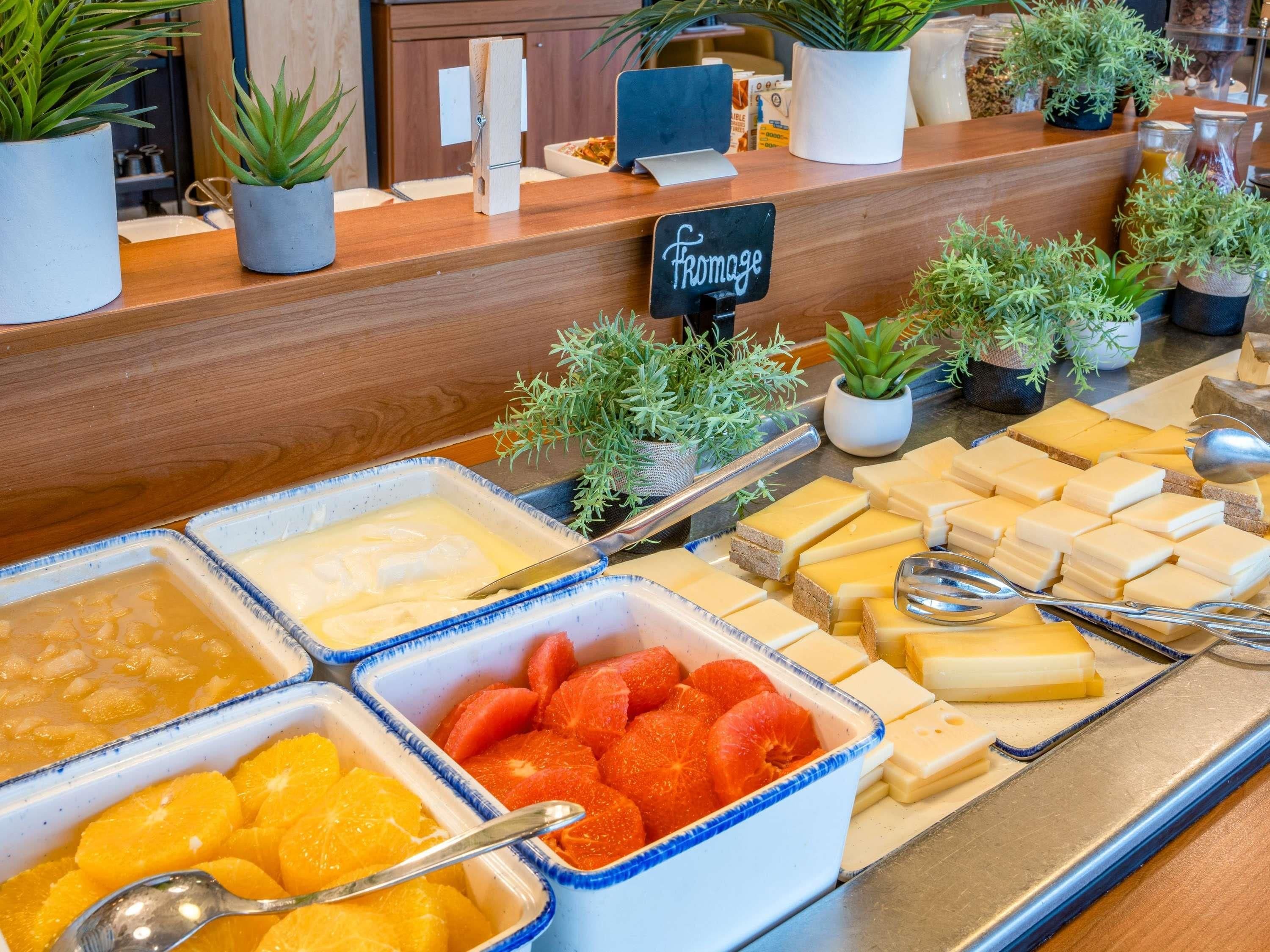 A buffet with various food items including fruits, cheeses, and a sign labeled "fromage".