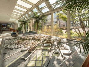 A model of a cityscape with a modern interior featuring a glass ceiling, seating area, and indoor plants. - ibis Paris 17 Clichy-Batignolles (Paris)