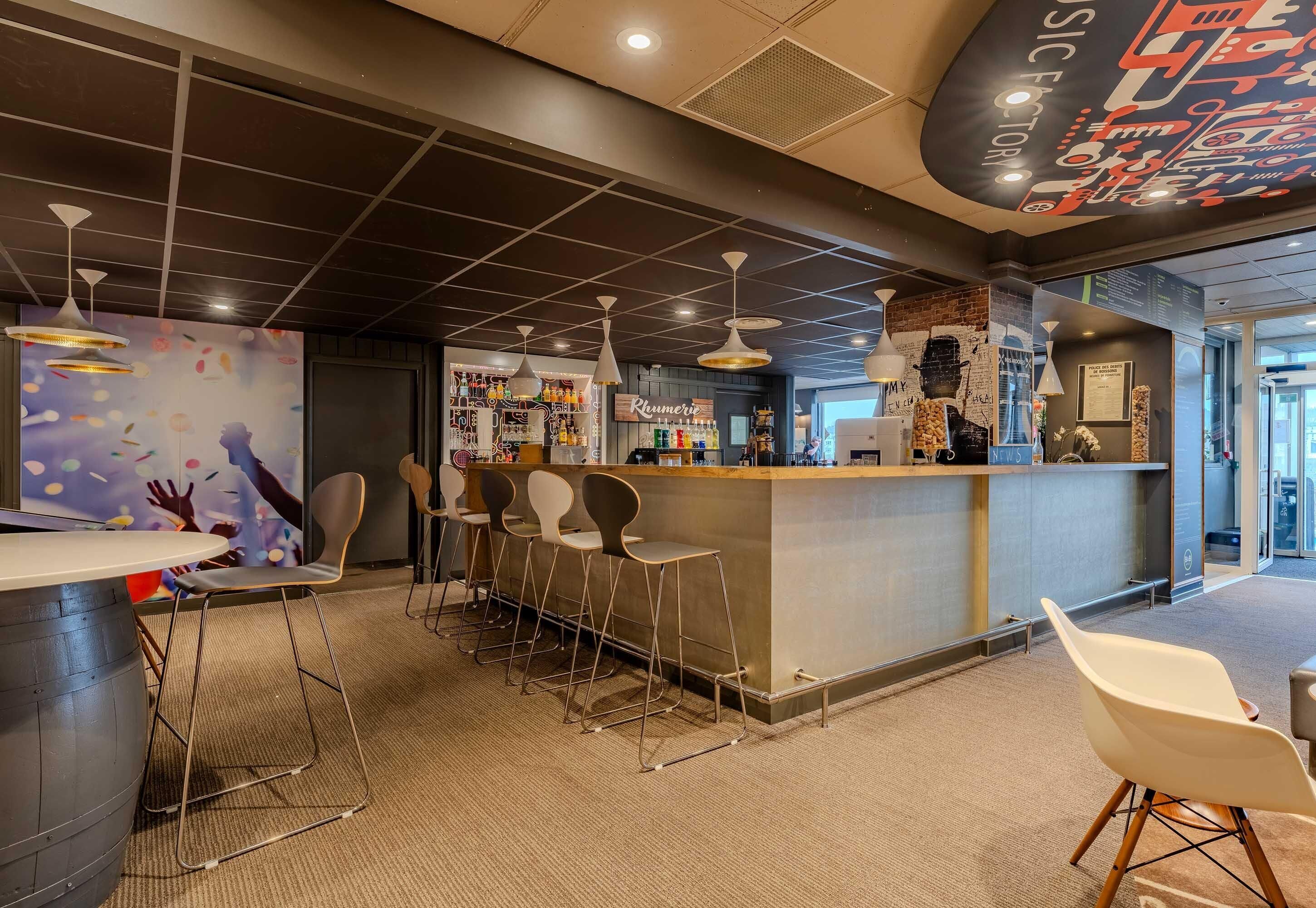 A bar area with a counter, stools, and a mural on the wall.
