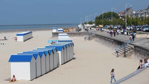A beach with beach huts, a promenade, and a clear view of the sea. - B&B Hotel Boulogne Sur Mer Centre Les Ports (Boulogne-sur-Mer)