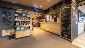A restaurant with a menu board, a counter, and shelves with bottles. - B&B Hotel Boulogne Sur Mer Centre Les Ports (Boulogne-sur-Mer)
