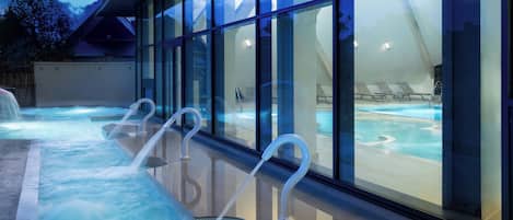Un área de spa moderna con un jacuzzi y sillones de descanso.