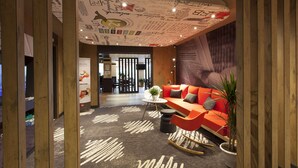 Un interior moderno con un sofá rojo, una mesita redonda y una planta en maceta.
