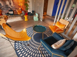 Ein moderner Lounge-Bereich mit verschiedenen Sitzmöglichkeiten, darunter eine Couch, Stühle und ein kleiner Tisch.
