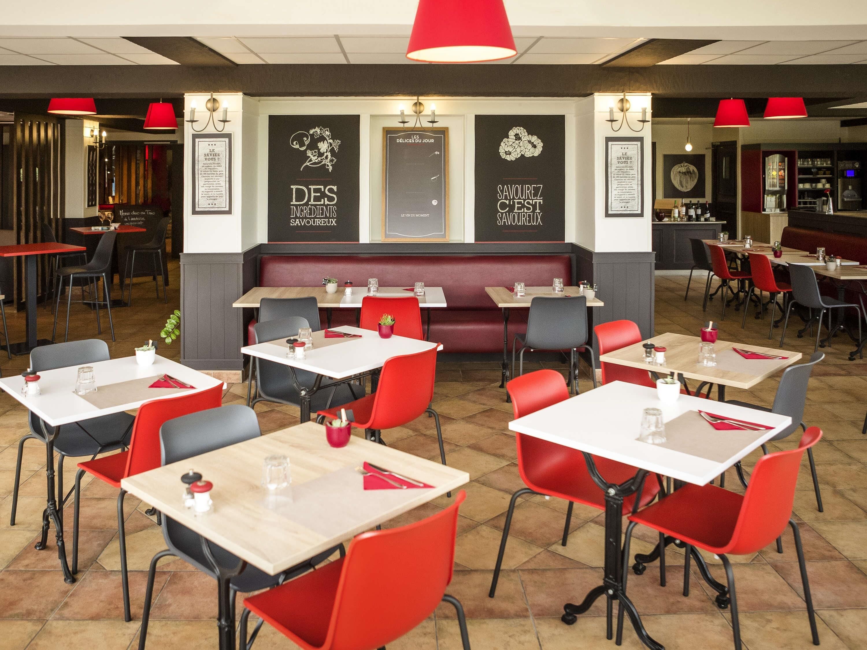 A restaurant interior with tables, chairs, and a red ceiling light.