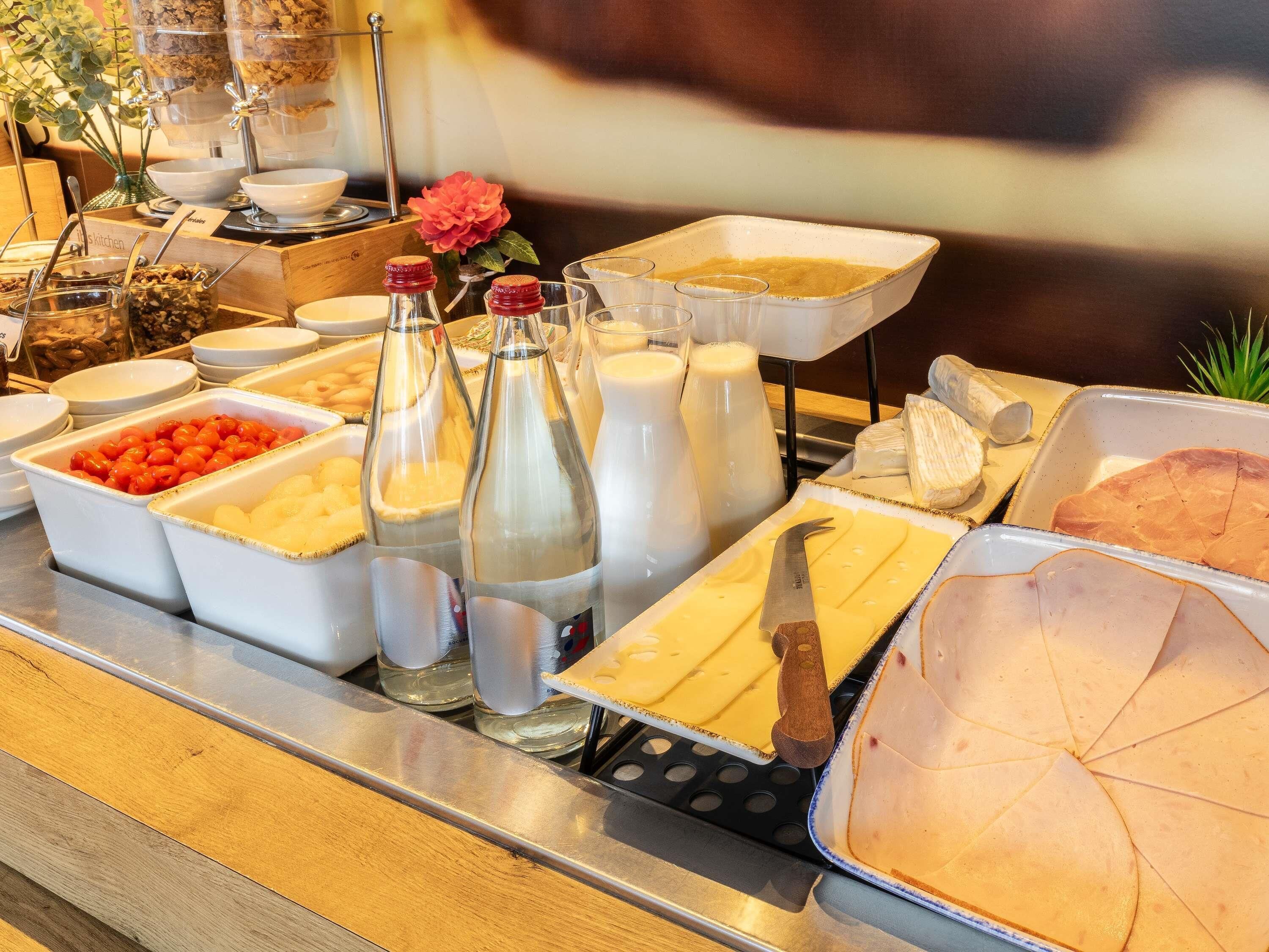 A buffet with various food items and condiments.
