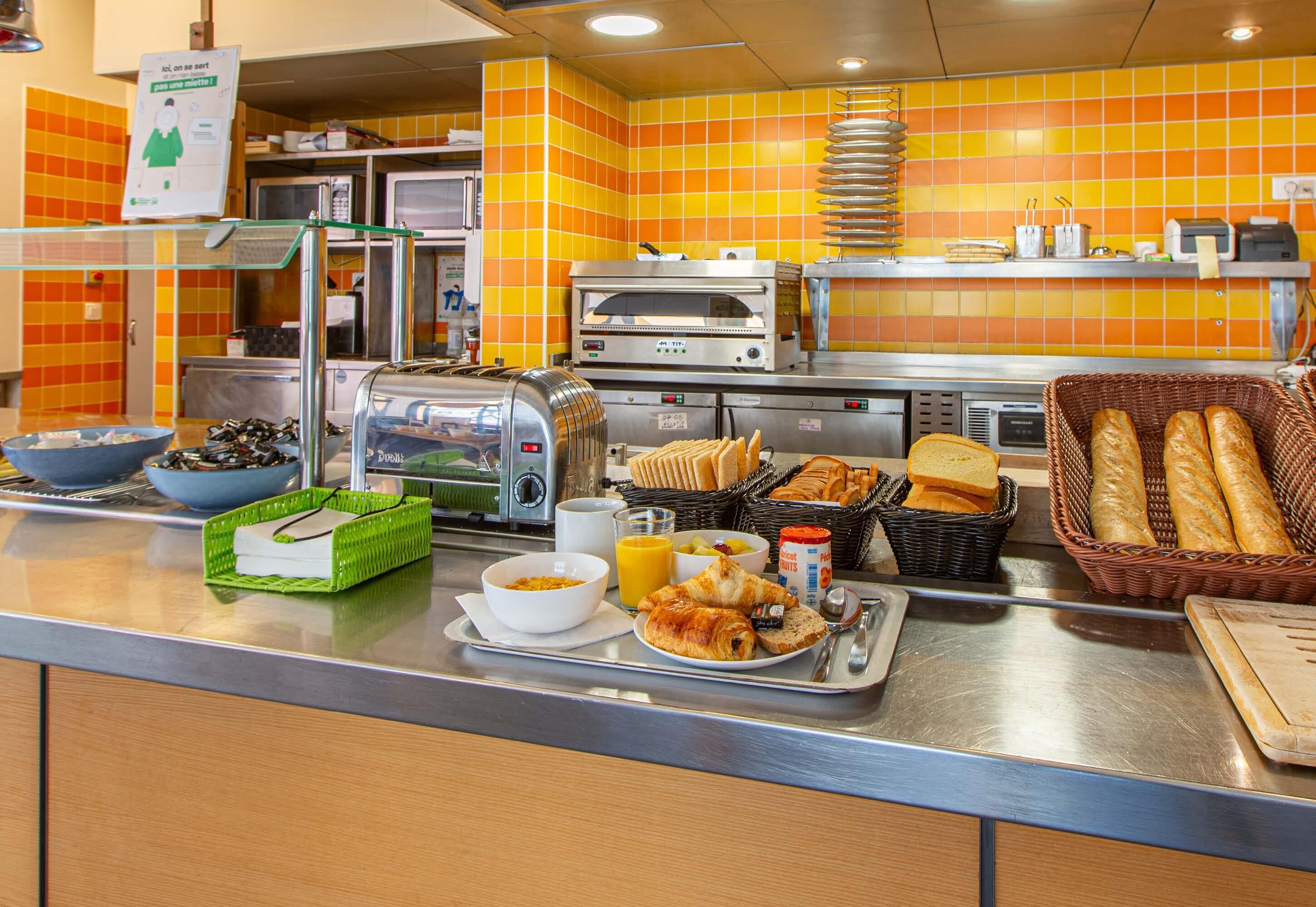 Un bufé de desayuno con diversas opciones de comida, un tostador y un microondas.