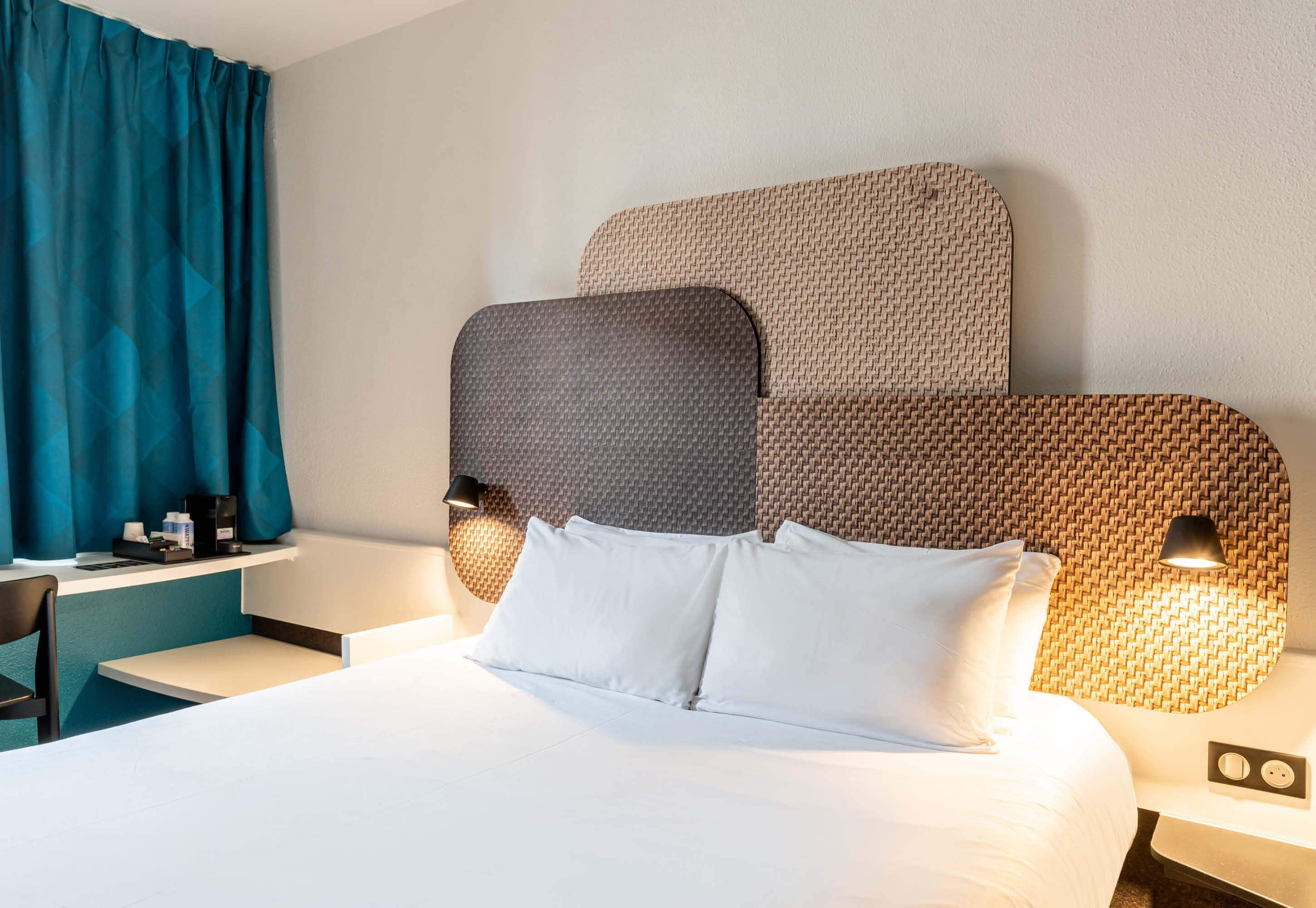 Ett hotellrum med en säng, ett skrivbord och en stol.