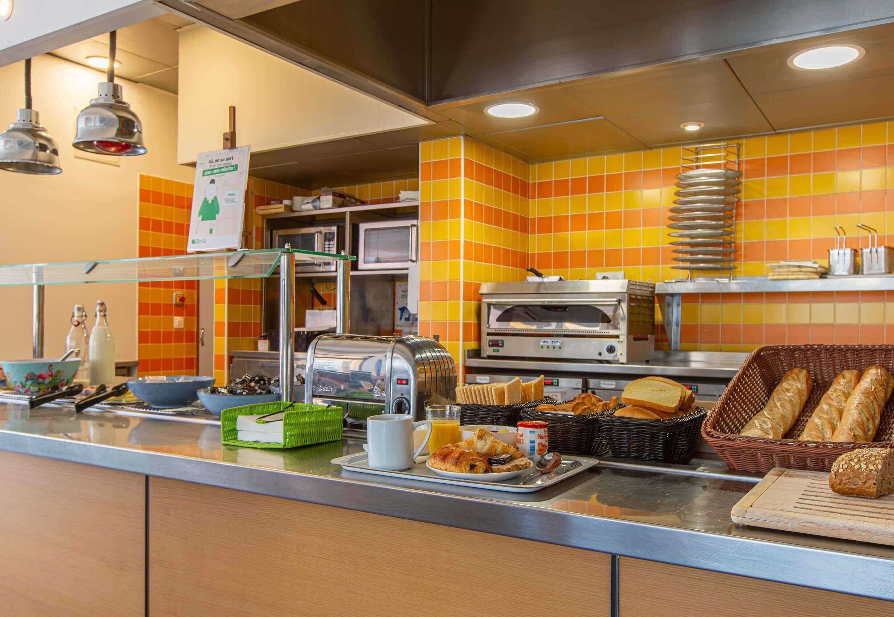 Un buffet de petit-déjeuner proposant une variété d’aliments, ainsi qu’un four à micro-ondes, un grille-pain et une machine à café.