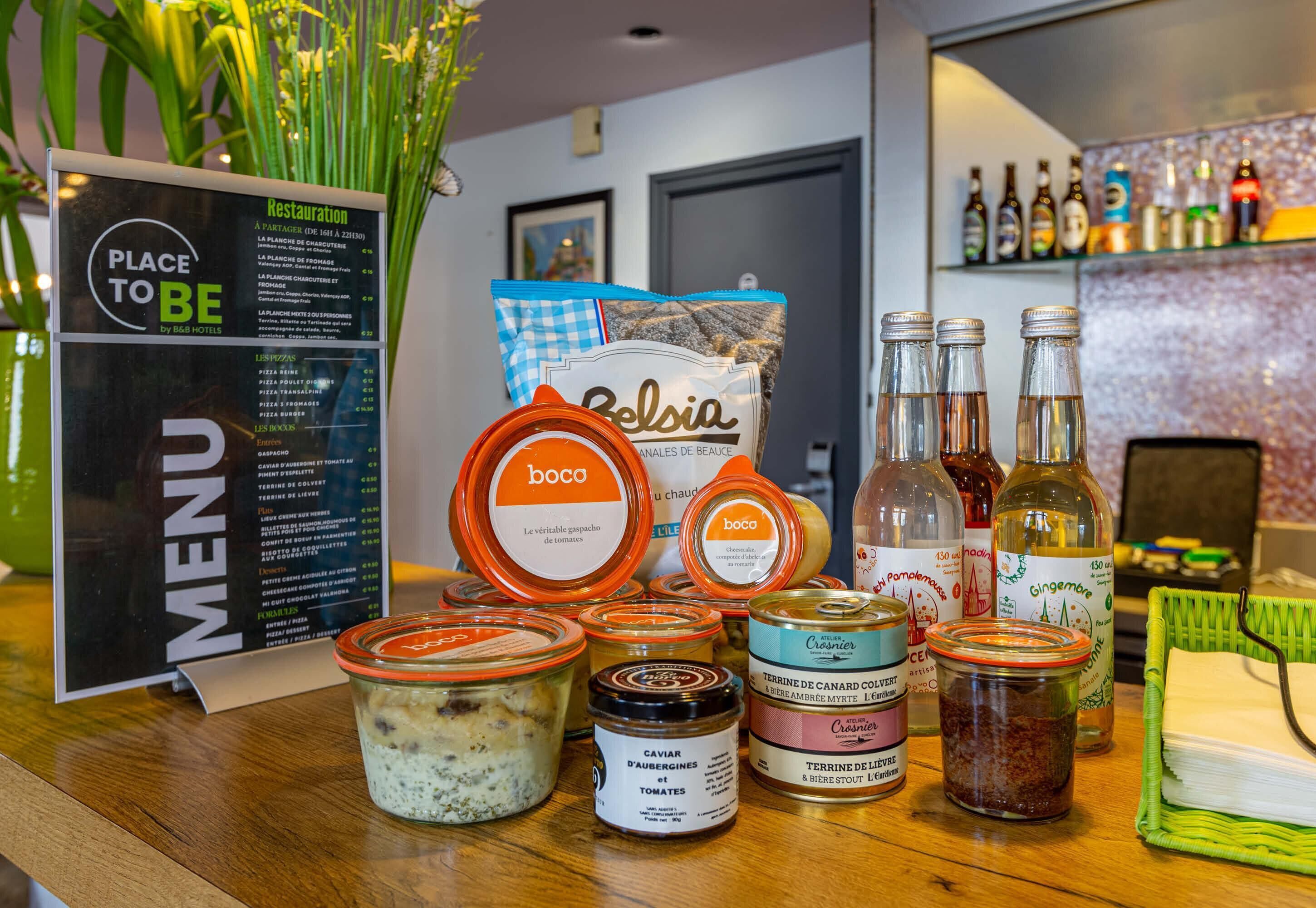 A restaurant counter with a menu, condiments, and bottles.
