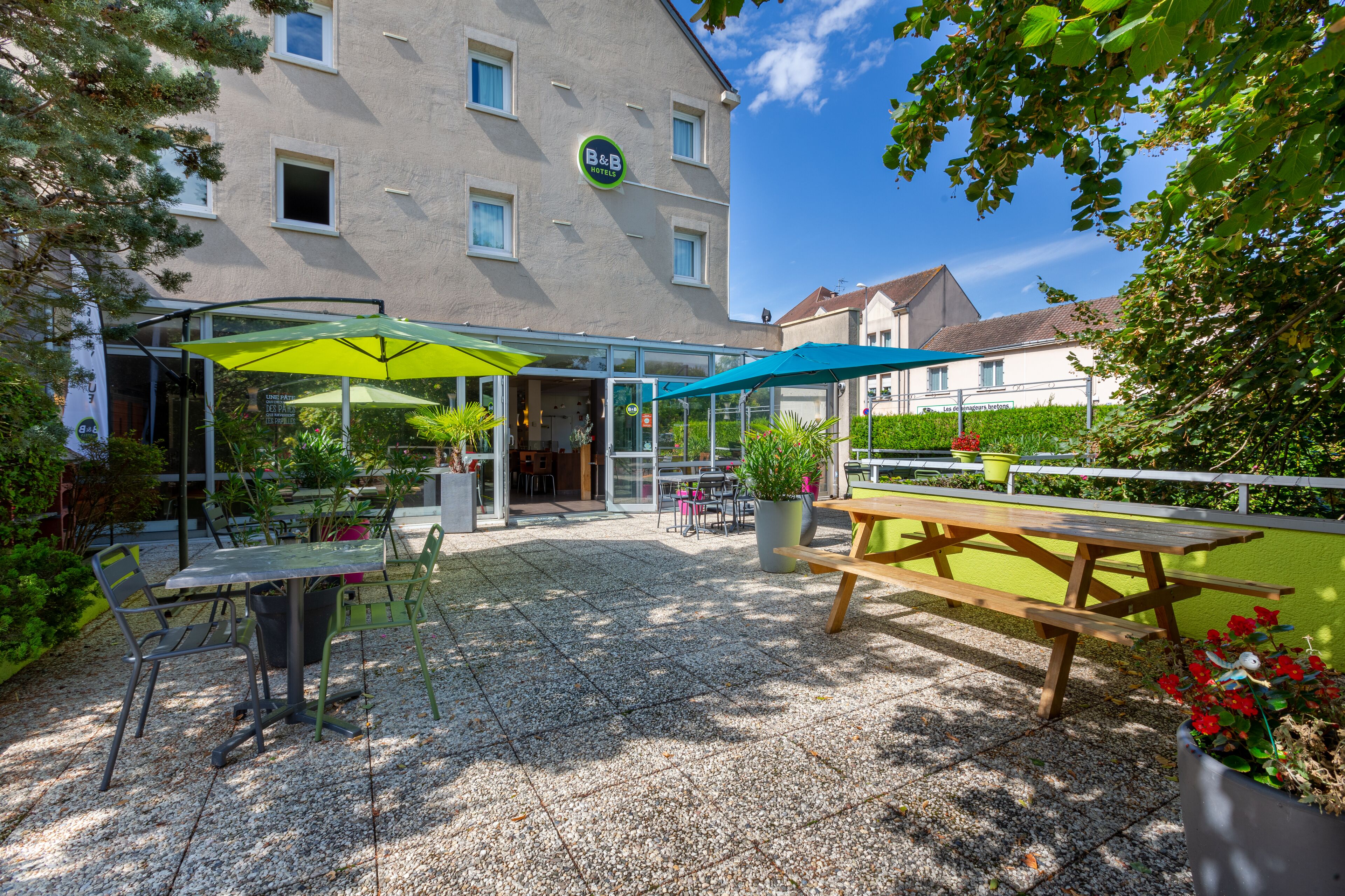 A hotel patio with outdoor seating, a covered area, and a visible entrance.