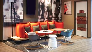 Een moderne zithoek met een bank, stoelen en een kleine tafel.