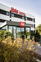 Un moderno edificio de hotel con el nombre 'ibis HOTEL' bien visible en la fachada.