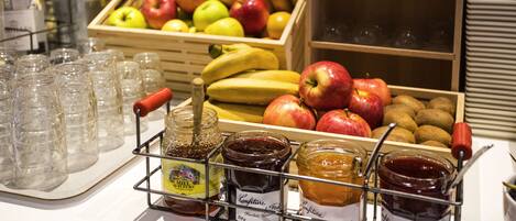 Exposição de frutas e compotas com um suporte para copos.