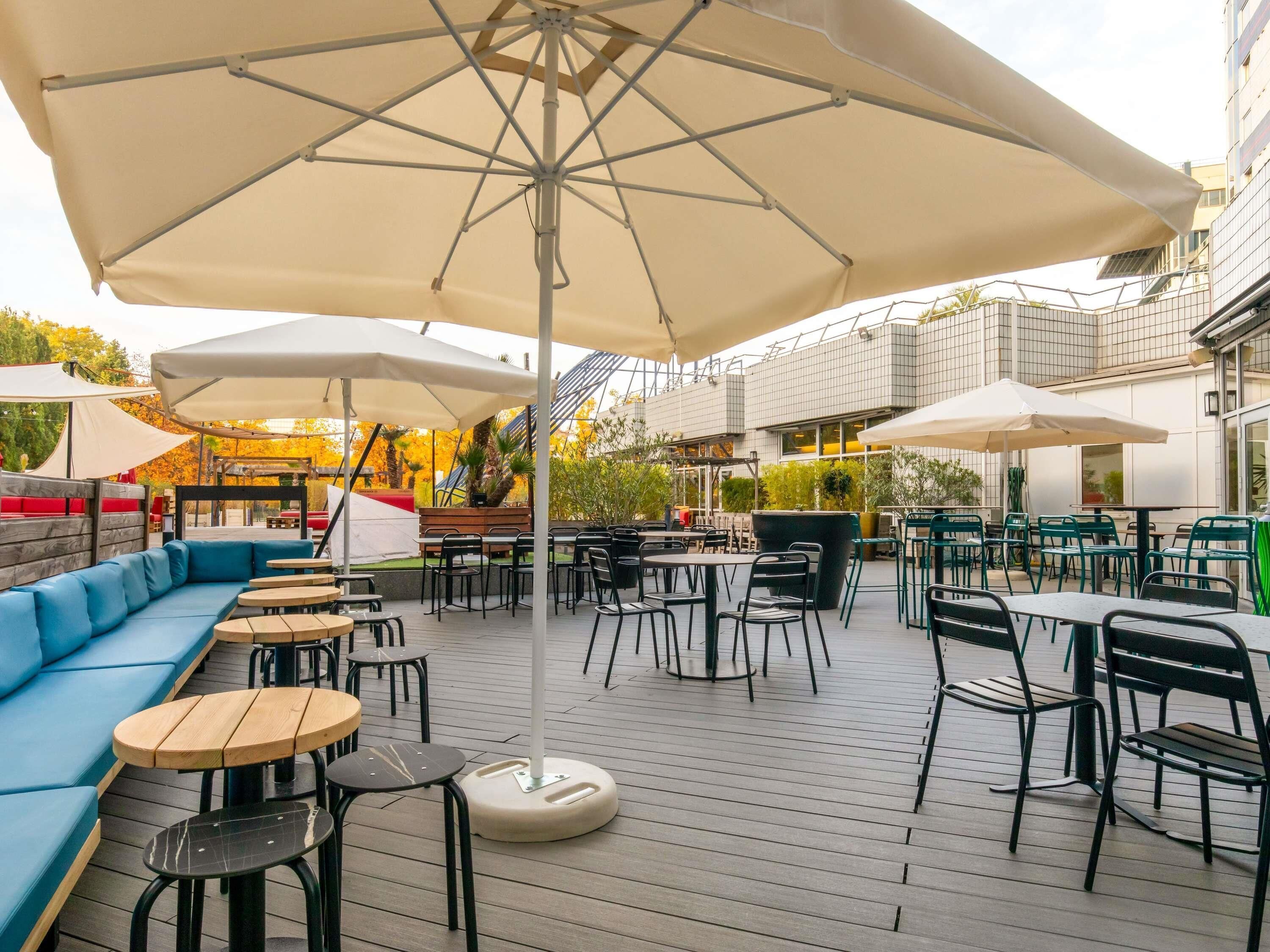 An outdoor patio with seating, tables, and umbrellas.