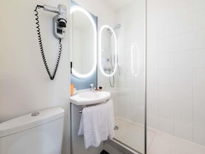 Un bagno con il water, lavandino e doccia.
