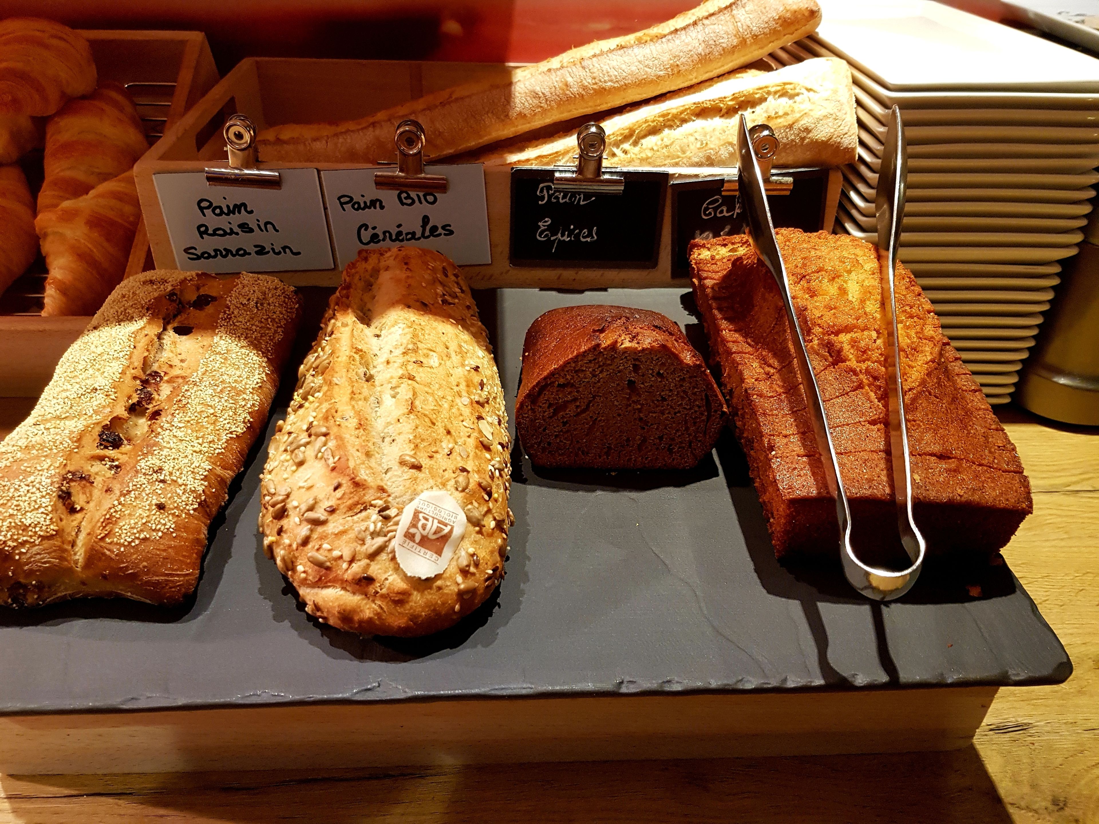 A selection of breads on a display board with labels.