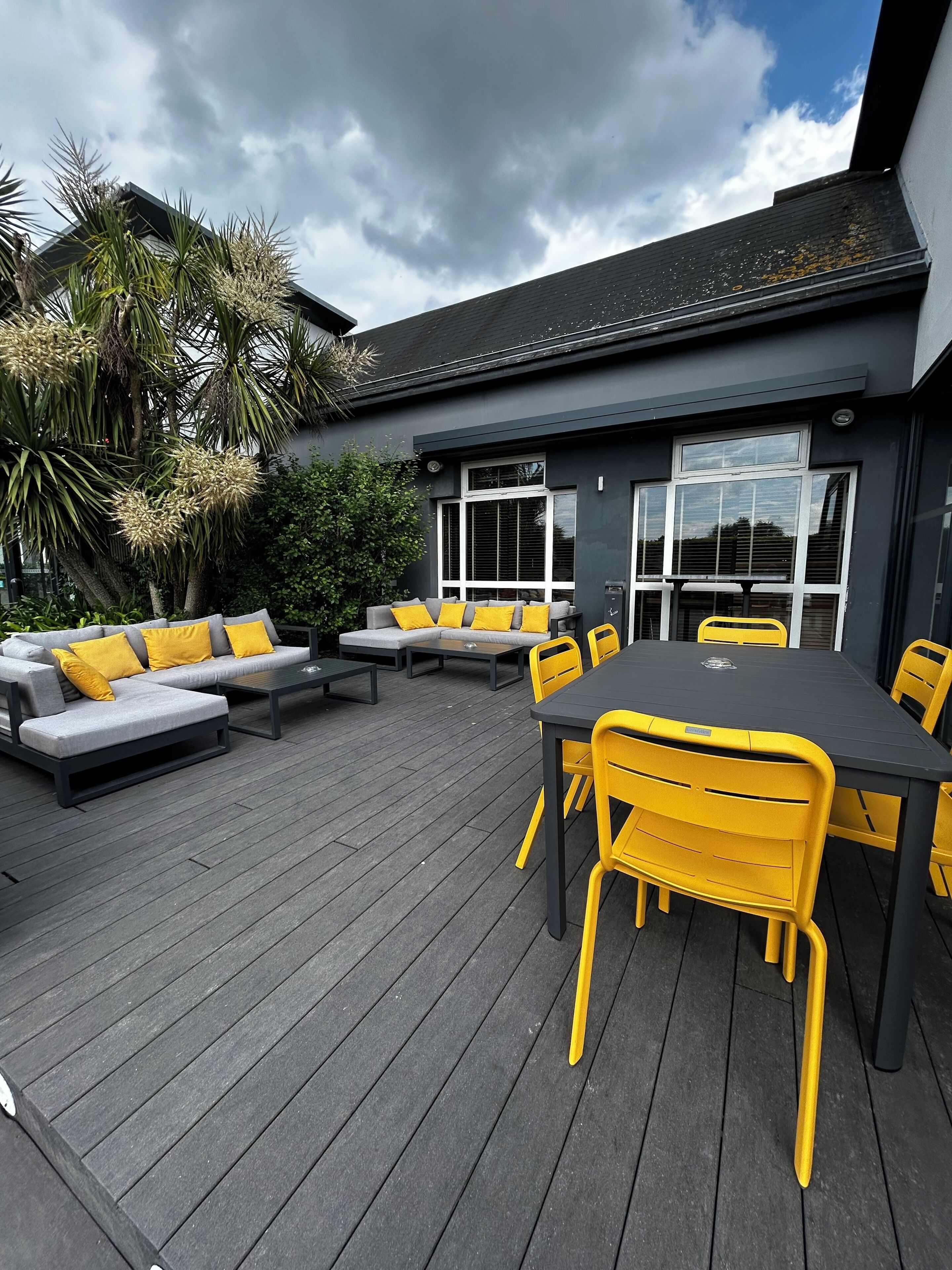 An outdoor deck with a sofa, chairs, and a table.