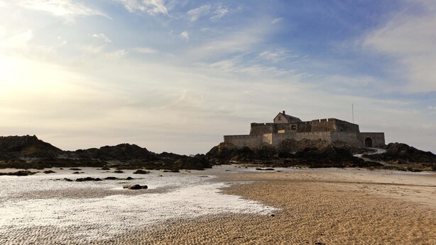 A coastal castle with a moat, situated on a sandy beach with rocky outcrops. - ibis Saint Malo La Madeleine (Saint-Malo)
