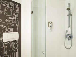 Ein modernes Badezimmer mit Dusche, Toilette und Handtuchhalter.