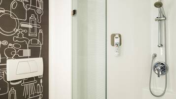 Un baño moderno con ducha, inodoro y toallero.