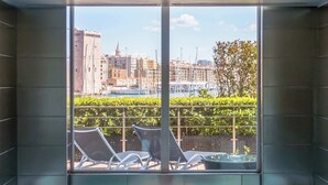 A man relaxing in a hot tub with a city view through large windows. - Sofitel Marseille Vieux Port (Marseille)