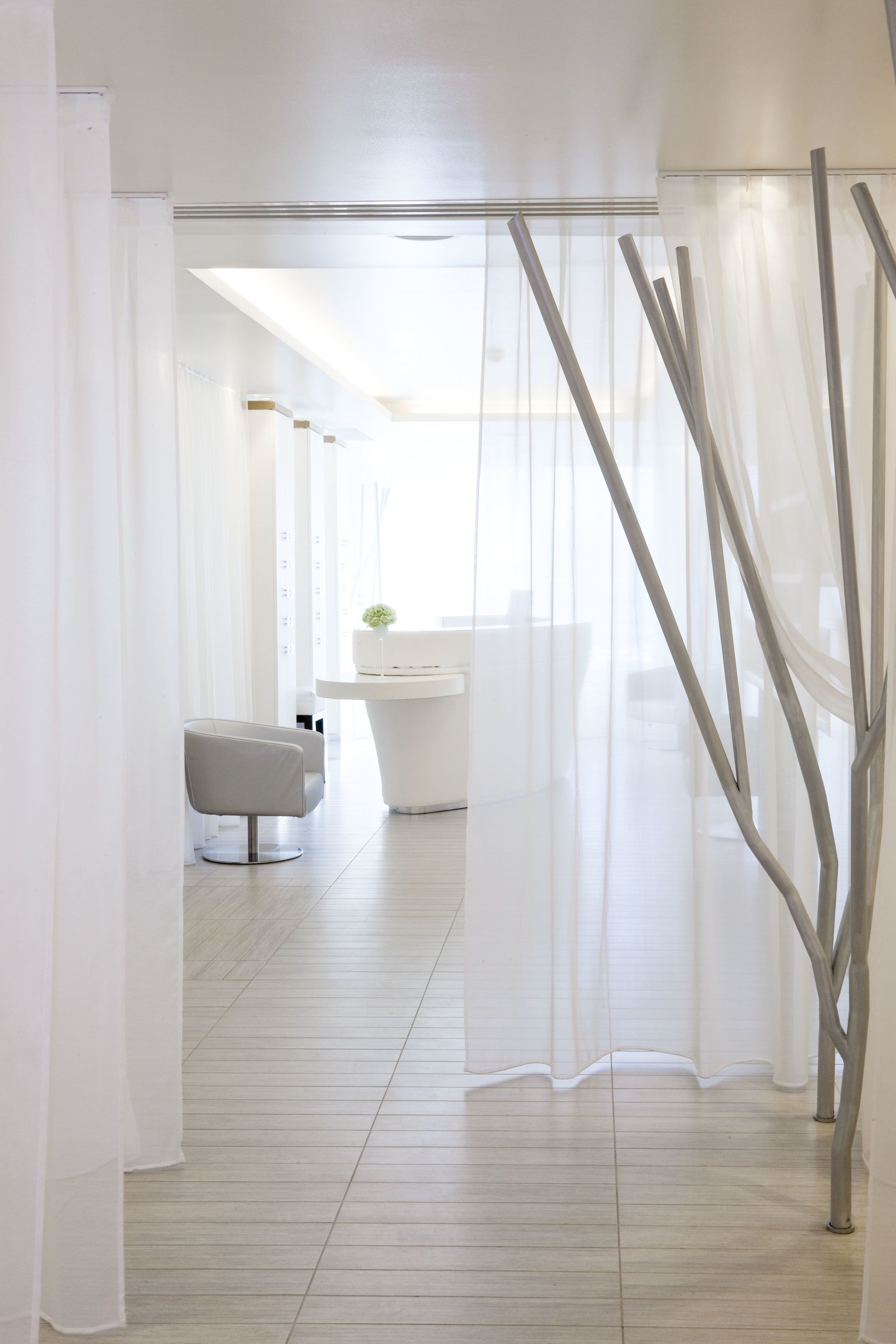 Une salle de bain moderne avec un lavabo blanc, un miroir et une chaise.