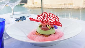 A dessert on a white plate with a city view in the background.