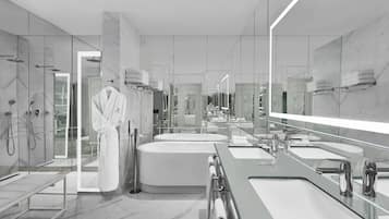 A modern bathroom with a large mirror, multiple sinks, and a robe rack.