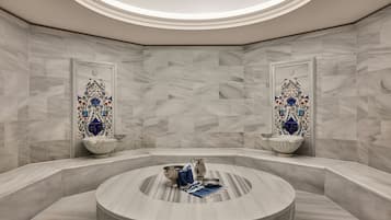 Un baño moderno con un lavamanos de mármol circular, dos azulejos decorativos y un tragaluz.