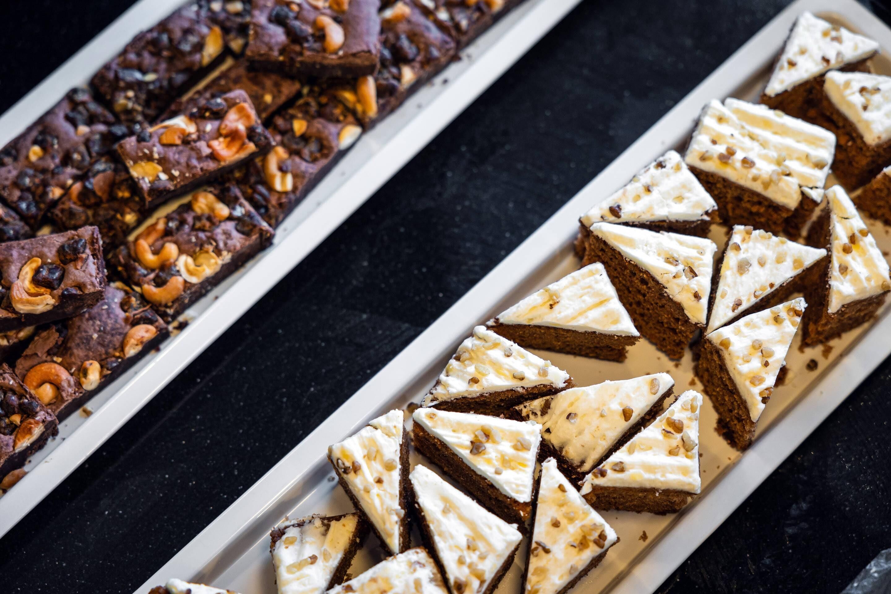 A tray of brownies and a tray of cake slices.