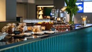 A buffet bar with various food items and a decorative plant. - Quality Hotel Prinsen (Trondheim)
