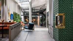 A modern lobby with a staircase, seating area, and decorative wall panels. - Quality Hotel Prinsen (Trondheim)