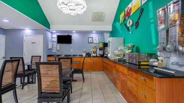 Un restaurante con armarios de madera, un mostrador con productos alimenticios y un televisor en la pared.