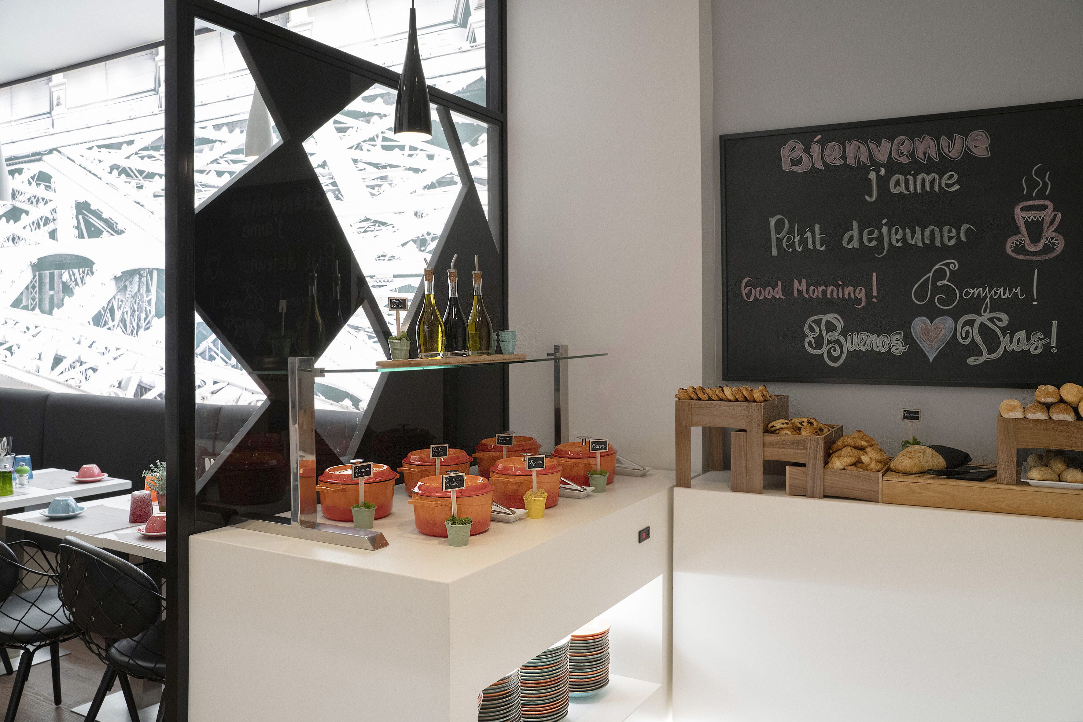 A breakfast buffet area with various food items and a chalkboard with greetings.