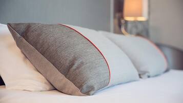 Un lit avec des oreillers et une lampe en arrière-plan.