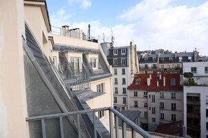 Un edificio de varios pisos con un balcón y una escalera.