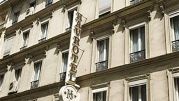 A multi-story hotel with a classic architectural style, featuring a prominent sign for the Grand Hotel Du Havre.