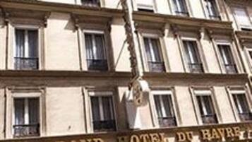Ett hotell med flera våningar och en klassisk fasad, med en framträdande skylt som visar texten ”GRAND HOTEL DE BAYRE”.